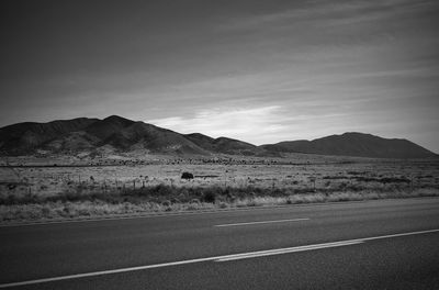 Scenic view of road by mountains against sky