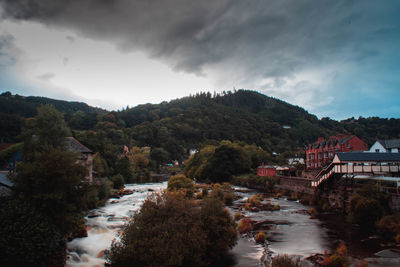 River amidst buildings in city against sky