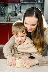 Mother and son preparing food on table