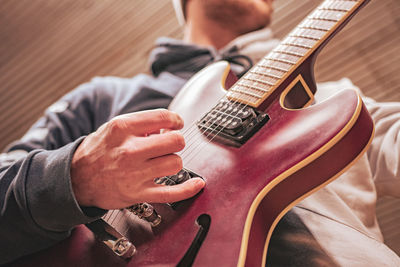 Midsection of man playing guitar