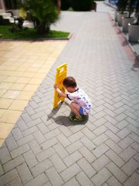 Boy holding information sign on footpath