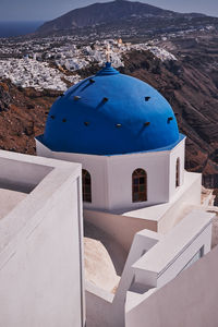 Anastasis church with its blue dome and tower in imerovigli village, santorini, greece