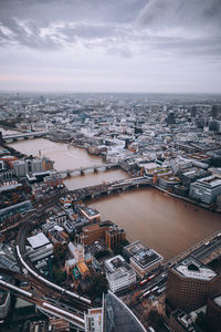 High angle view of city by river against sky