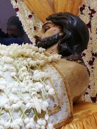 Close-up of woman with flowers on table