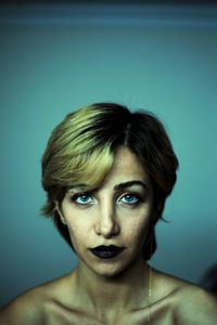 Portrait of young woman against gray background