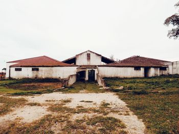 Old house on field against sky