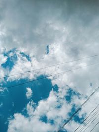 Low angle view of power cables against sky