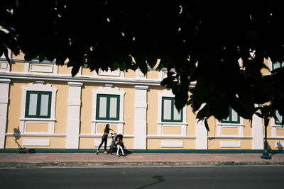 People riding bicycle on road in city