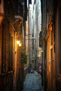 Illuminated alley amidst buildings in city