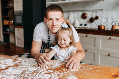 Funny happy dad and daughter baby cook together fool around and play with flour in  kitchen at home