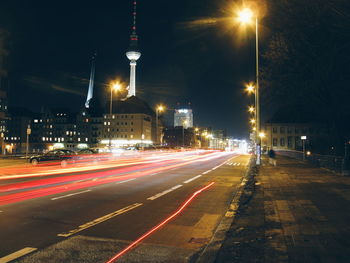 Light trails on road against sky in city at night