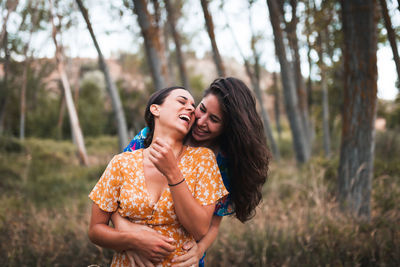 Happy lesbians embracing in forest