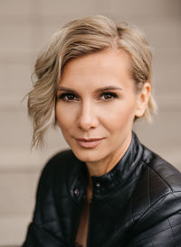 Portrait of a beautiful blonde woman in a black leather jacket. gentle female smile