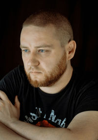 Portrait of young man against black background