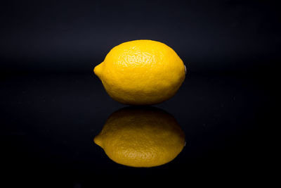 Close-up of oranges on table against black background