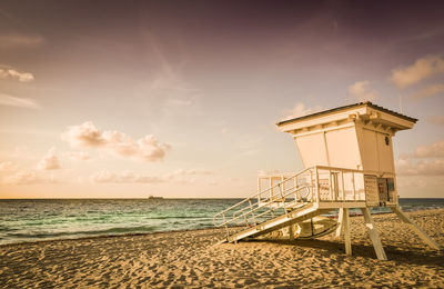 Lifeguard hut on beach against sky