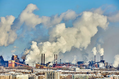 Smoke emitting from chimney against sky