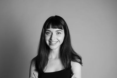 Portrait of smiling young woman against white background