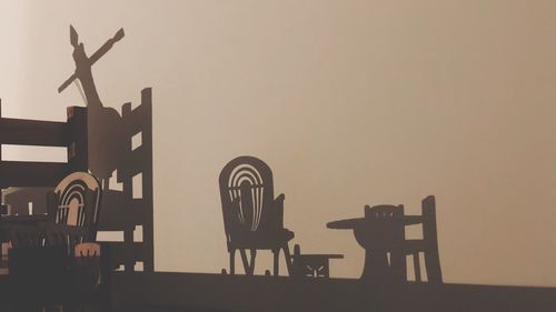 Birds on chair against clear sky