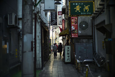 Rear view of woman walking on street in city