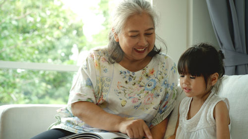 Grandmother teaching granddaughter at home