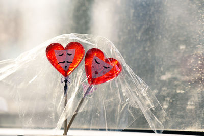 Two heart-shaped lollipops with painted male and female faces