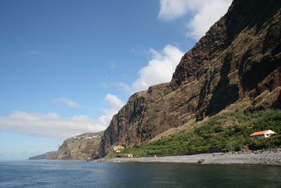 Scenic view of sea and mountains against cloudy sky