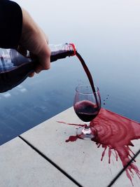 Cropped image of hand holding glass of red wine