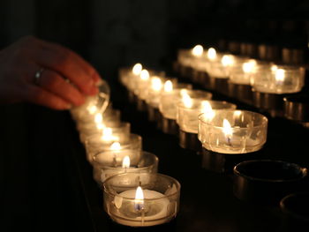 Cropped image of hand igniting candle