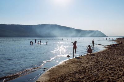 People at beach against sky