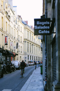 People walking on street amidst buildings in city