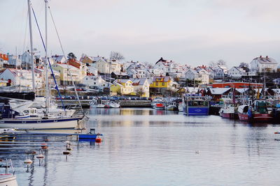 Boats moored at harbor against sky