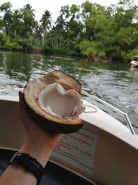 Midsection of person holding ice cream in lake