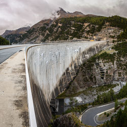 Scenic view of dam and mountains against sky