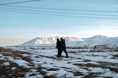 Man standing on snowcapped mountain against sky