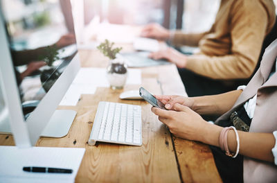 Midsection of woman using laptop on table