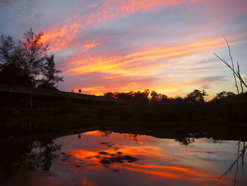 Scenic view of lake against orange sky