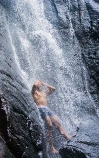 Man enjoying under waterfall