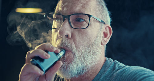 Close-up portrait of man holding eyeglasses