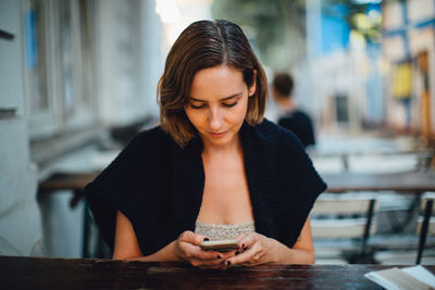 Teenage girl looking away while using mobile phone