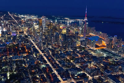 High angle view of illuminated cityscape against sky at night