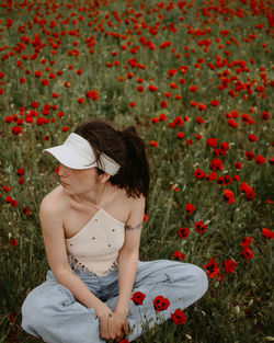 Rear view of woman sitting on field