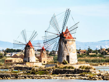 Traditional windmill on landscape against sky