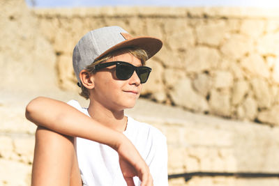 Portrait of man wearing sunglasses against wall