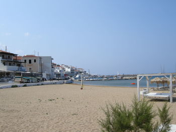 Boats in sea against clear blue sky