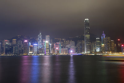 Illuminated buildings in city against sky at night