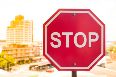 Close-up of stop sign in city against clear sky