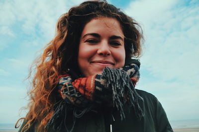 Portrait of smiling woman in winter against sky