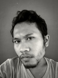 Close-up portrait of young man against wall