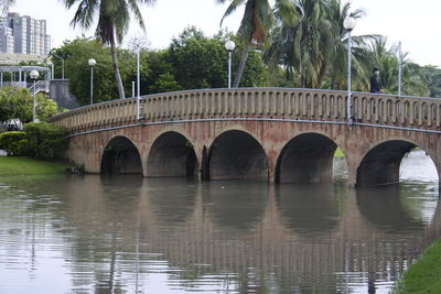 Bridge over river in city against sky